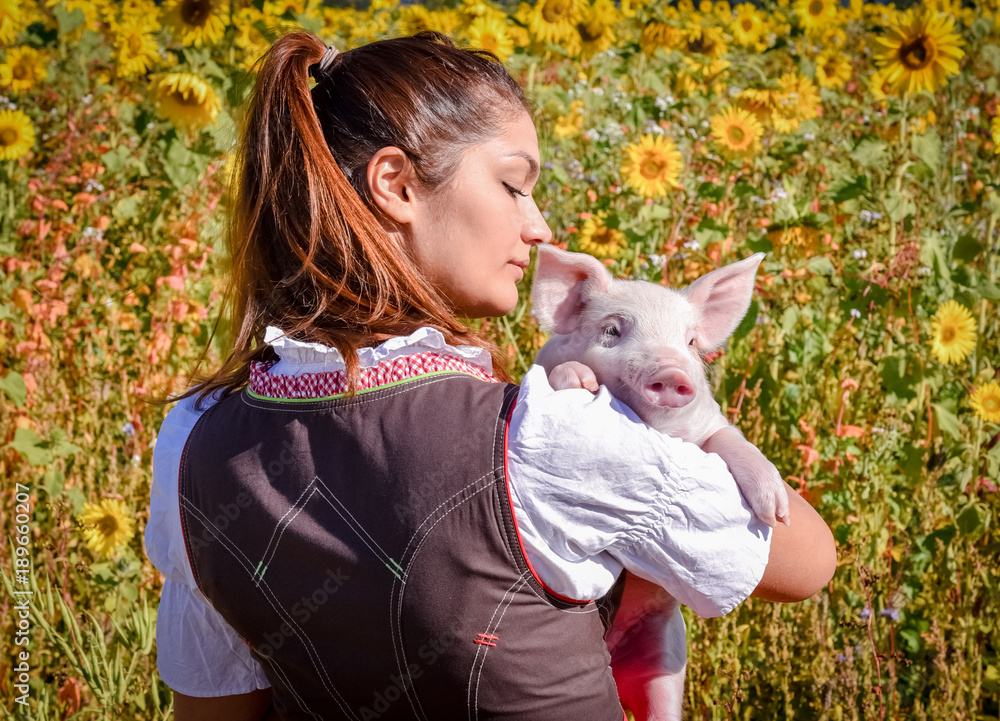 Kurios - junge Frau mit Ferkel im Arm vor Sonnenblumen Kurios - junge Frau mit Ferkel im Arm vor Sonnenblumen