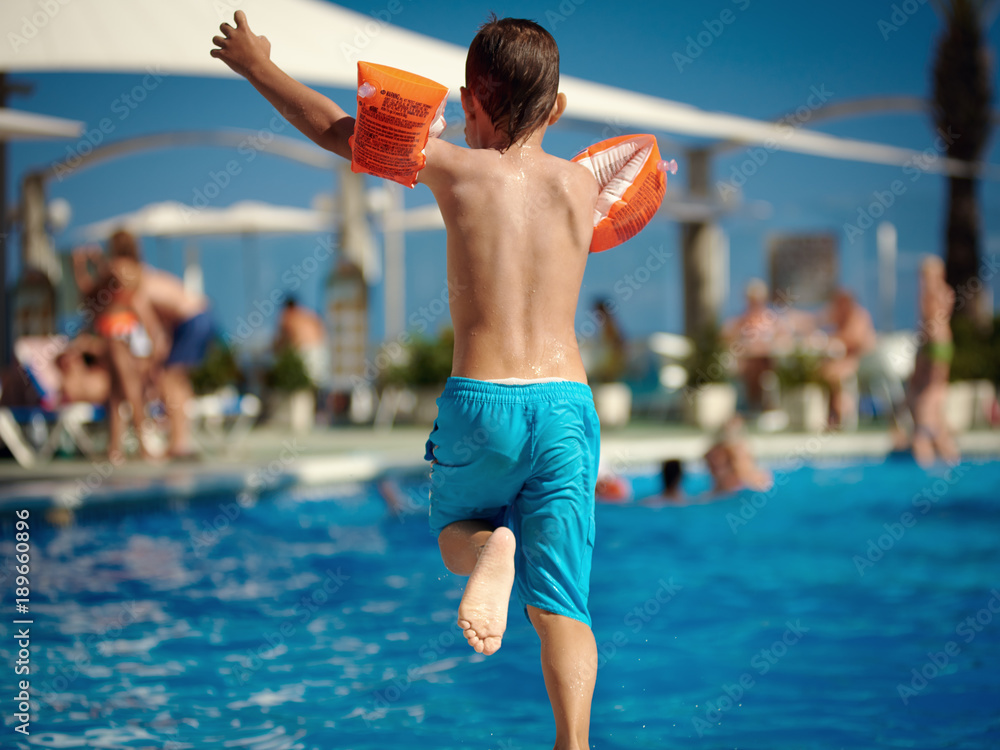 European child running to jump into the pool.
