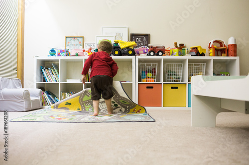 Billede på lærred Toddler cleaning up playroom