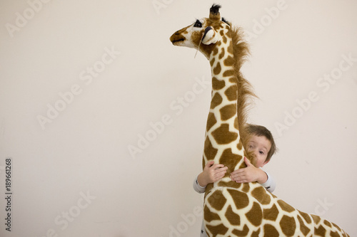 Photography Young boy and his stuffed giraffe