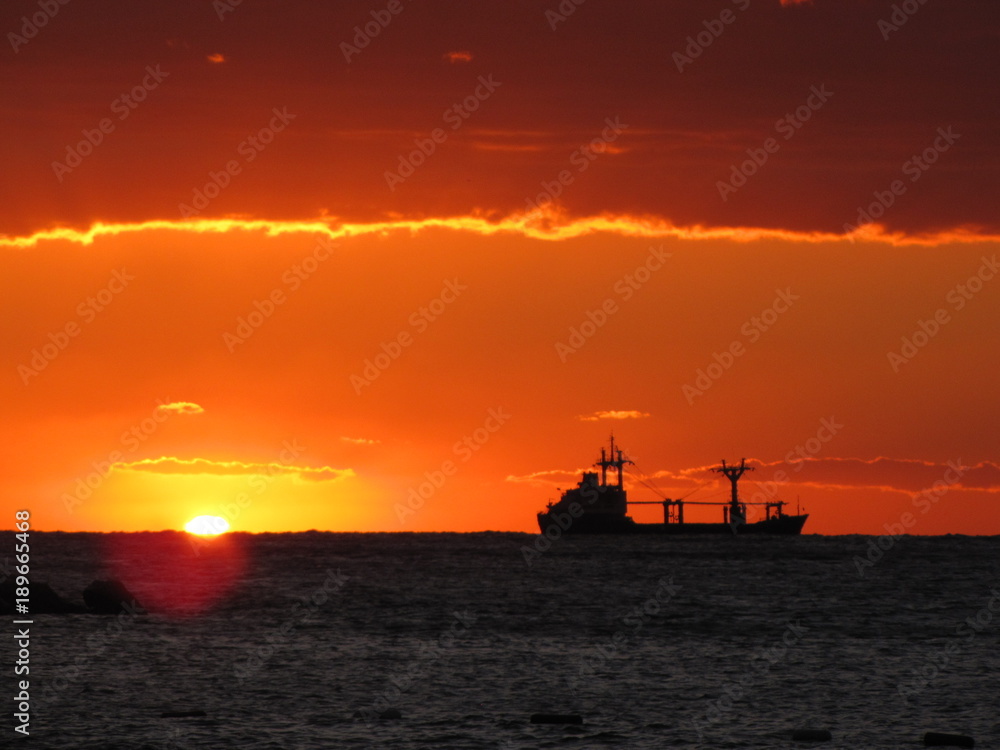 Cargo ship on the Adritic sea in sunset. Europe. Adriatic sea of Mediterranean area. Montenegro`s coastline. Atumn 2012. 