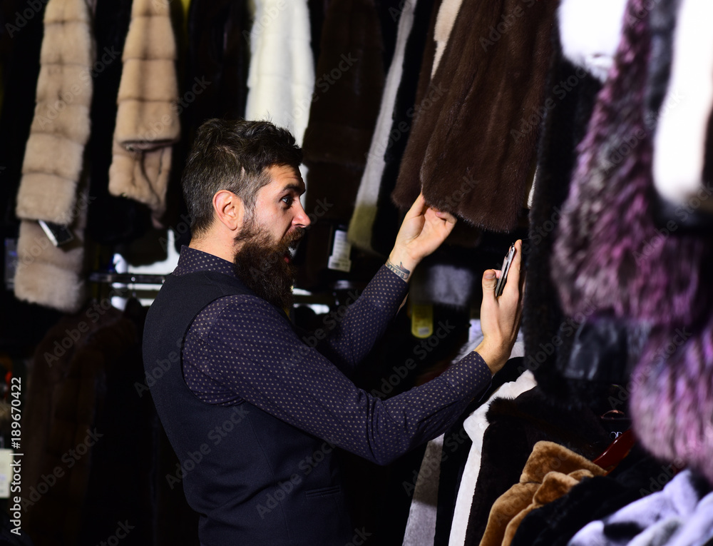 Man with beard and mustache looking for fur coat.