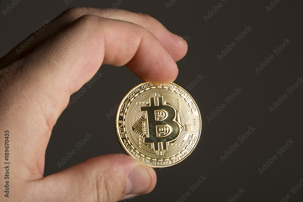 Coin bitcoin in hand on a dark background Coin bitcoin in hand on a dark background
