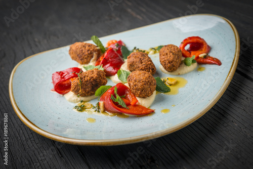 Falafel medallions with hummus, tahini dressing, roasted papper and garlic