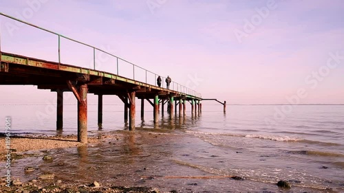 a romantic couple walking on a pier at the Tagus river, Lisbon, Portugal photo