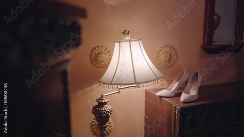 bride's shoes. Standing on the table. Background light wall. Around a floor lamp. photo