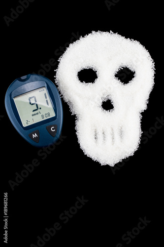 Deadly sugar addiction suggested by spilled white sugar crystals forming a skull. Diabetes mellitus concept photo