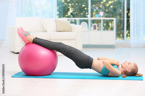 Young woman in sportswear doing exercises indoors