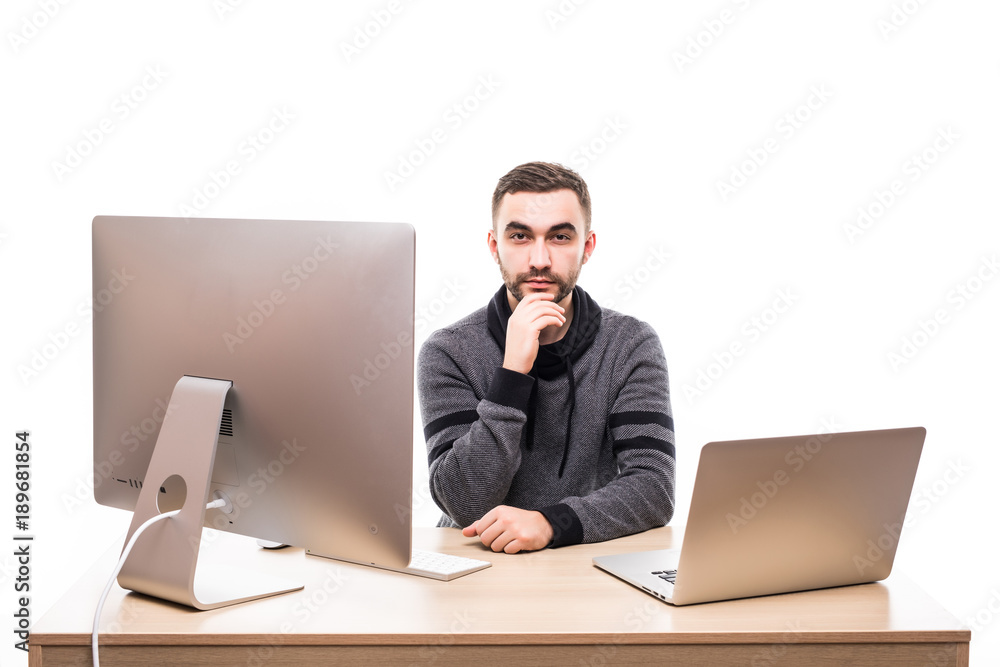 Confident businessman sitting at the table with laptop and personal computer and looking at camera isolated on white background Confident businessman sitting at the table with laptop and personal computer and looking at camera isolated on white background