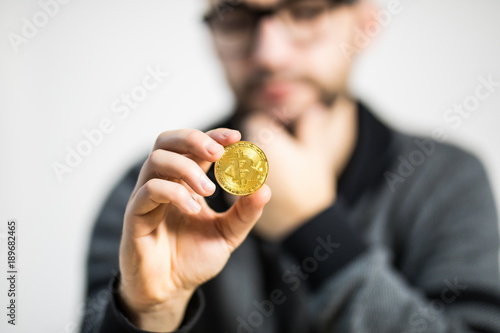 Close up of man hands with bitcoin with thinking man face on background
