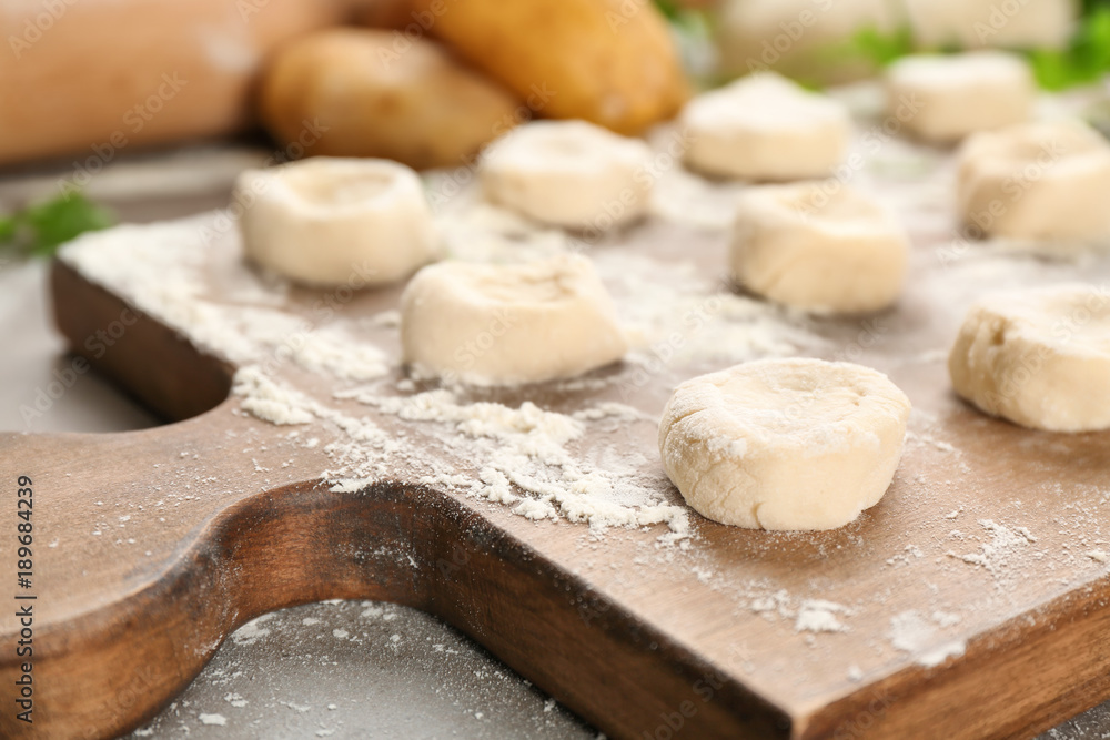 Raw dough for dumplings on wooden board Raw dough for dumplings on wooden board