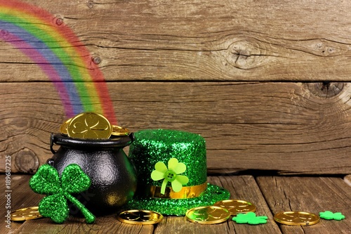 St Patricks Day Pot of Gold with rainbow, shamrocks and hat against rustic wood photo