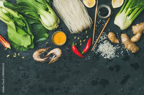 Asian cuisine ingredients over black background, top view, copy space. Flat-lay of vegetables, spices and sauces for cooking vietnamese, thai or chinese food. Clean eating, vegetarian diet concept