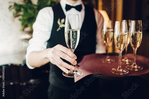 waiter brings glasses of champagne photo