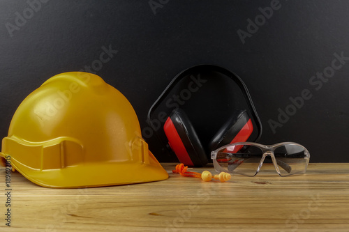 HEALTH AND SAFETY CONCEPT. Personal protective equipment on wooden table over black background. photo