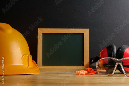 HEALTH AND SAFETY CONCEPT. Personal protective equipment on wooden table over black background. photo