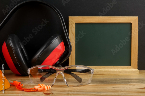 HEALTH AND SAFETY CONCEPT. Personal protective equipment on wooden table over black background. photo