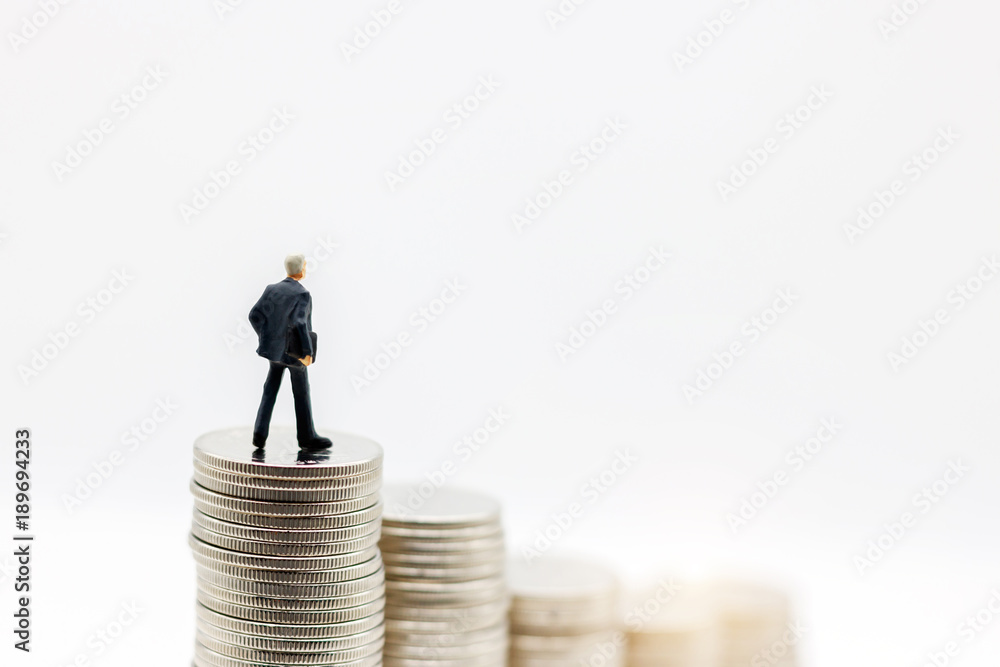 Miniature people: Businessman standing on step of coin money. Concept of Financial and money. Miniature people: Businessman standing on step of coin money. Concept of Financial and money.