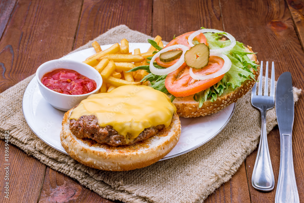 open cheeseburger on wooden background