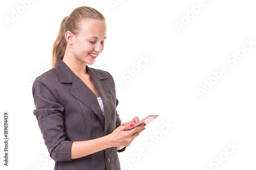 Beautiful young caucasian businesswoman in grey suit using smartphone. Studio shooting isolated on white