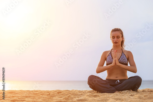 Woman playing Yoga and exercise on the tropical beach in sunset time. With space for text or design