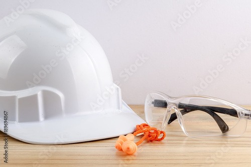 HEALTH AND SAFETY CONCEPT. Personal protective equipment on wooden table over white background.