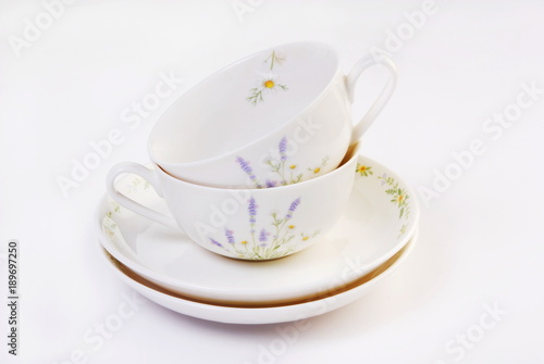 Two antique teacups stacked  on white background