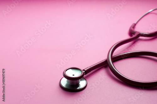 Red stethoscope on pink background Health care concept