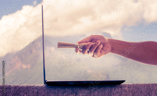 Hand holding letter and send it to laptop.Internet helps make life more comfortable.Career of millennials generation should be working anywhere.Balance your work time and life time.