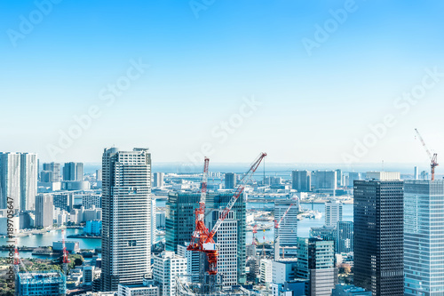 Asia Business concept for real estate and corporate construction - panoramic modern city skyline bird eye aerial view with crane near tokyo tower under bright sun and vivid blue sky in Tokyo, Japan © voyata