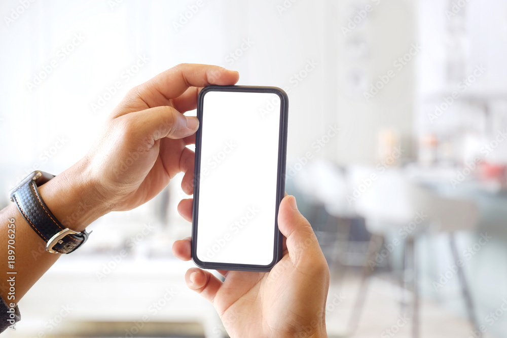Closeup shot of an unidentifiable man using a smartphone at living room background.