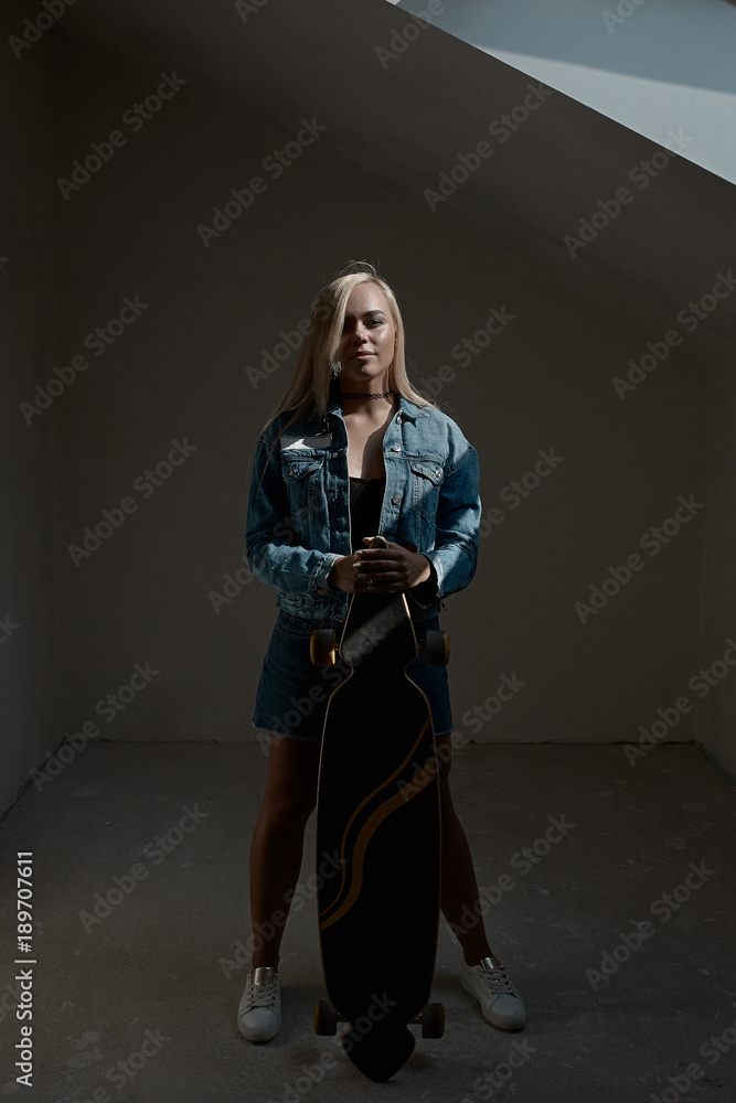 Fototapeta premium Beautiful blond girl posing with a loangboard