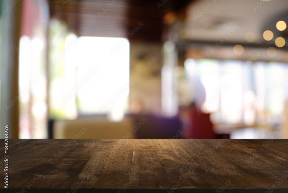 Empty wooden table in front of abstract blurred background of coffee shop . can be used for display or montage your products.Mock up for display of product. Empty wooden table in front of abstract blurred background of coffee shop . can be used for display or montage your products.Mock up for display of product.