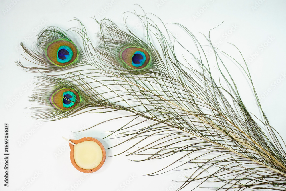 Obraz premium Top or flat lay view of a peacock feathers on a white background with a words HAPPY THAIPUSAM DAY. Celebrate by a hindu religions. A religions conceptual.