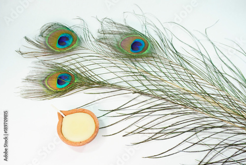 Top or flat lay view of a peacock feathers on a white background with a words HAPPY THAIPUSAM DAY. Celebrate by a hindu religions.  A religions conceptual.