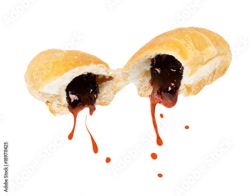 Fruit jam flowing from two halves of a croissant, isolated on white background photo