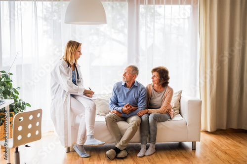 Female doctor talking to a senior couple.