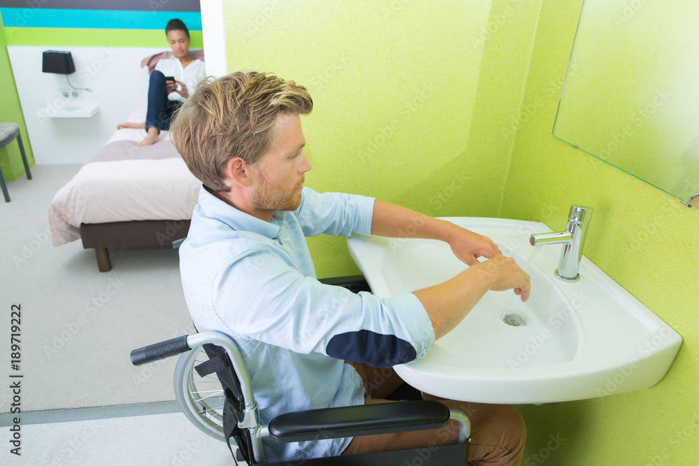 Disabled man washing hands at sink - obrazy, fototapety, plakaty 