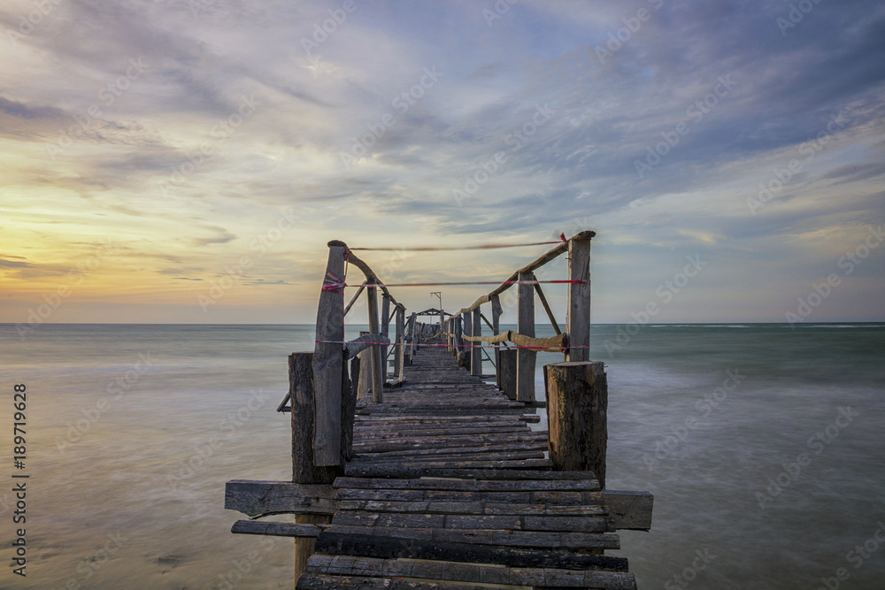 Old wooden jetty at Tamui Beach, Kuala Penyu Sabah during sunset. Long exposure image with motion blur. Old wooden jetty at Tamui Beach, Kuala Penyu Sabah during sunset. Long exposure image with motion blur.