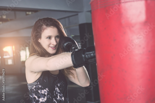 Young caucasian woman doing exercise with Thai boxing (Muay Thai) equipment in gym. Health and fitness concept. © SKT Studio