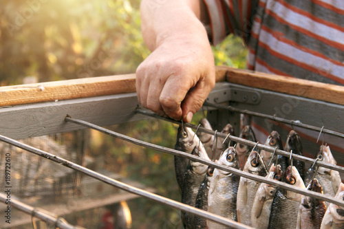 fish roach, ramming is dried after pickling and soaking. Special box for protection against flies insects. Salted and soaked fish hung on metal hooks inmesh aerated box. Dried jerky vobla ramming carp photo