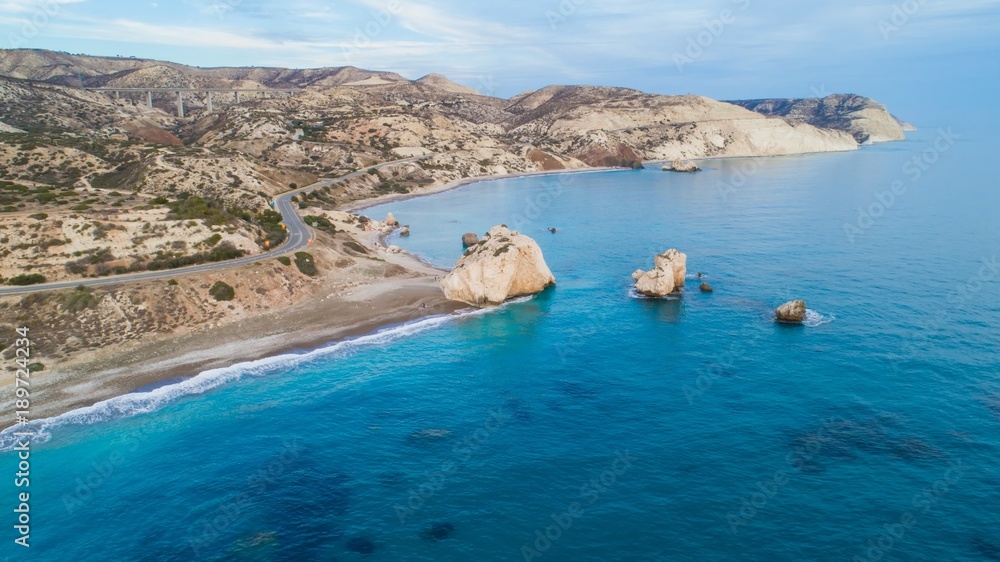 Obraz premium Widok z lotu ptaka ptaka Petra tou Romiou, skała aka Aphrodite's słynny punkt orientacyjny podróży turystycznych w Paphos, Cypr. Zatoka morska bogini Afroditi miejsce narodzin o zachodzie słońca z góry.
