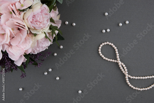 Fotografie bouquet of roses with pearl necklace on grey background