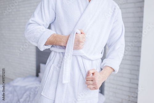mid section of man wearing bathrobe at home