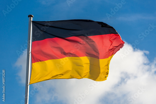 German flag waggling in the wind with blue sky
