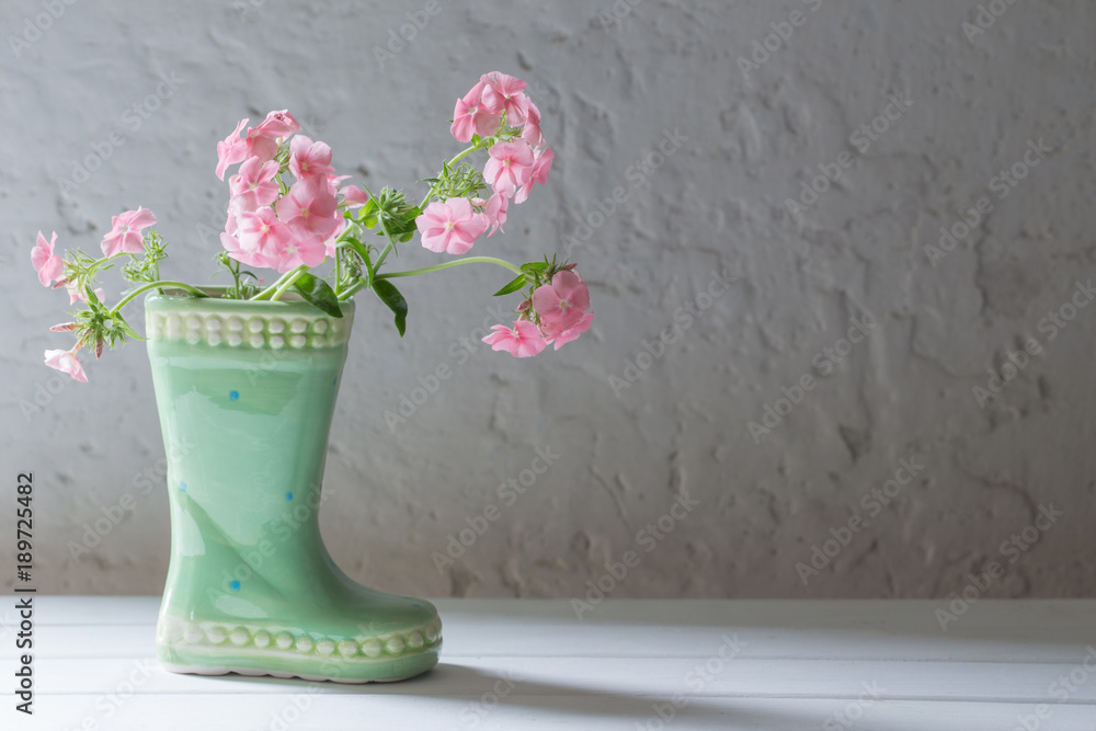 summer flowers in ceramic boot on white background summer flowers in ceramic boot on white background