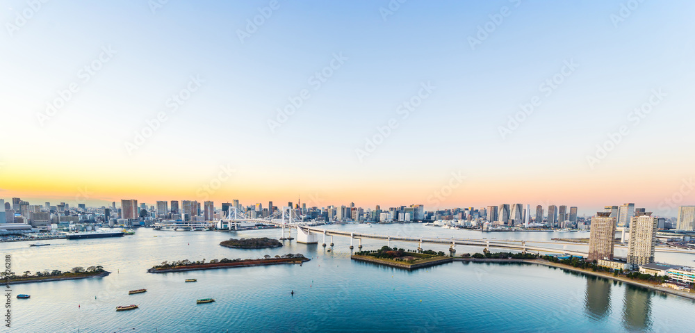 Asia Business concept for real estate and corporate construction - panoramic modern city skyline bird eye aerial view of Odaiba, tokyo tower & rainbow bridge under golden sun in Tokyo, Japan