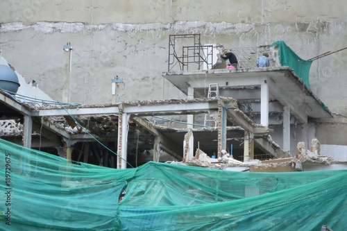 Construction scaffolding with green cover at the building. Construction and industry concept.