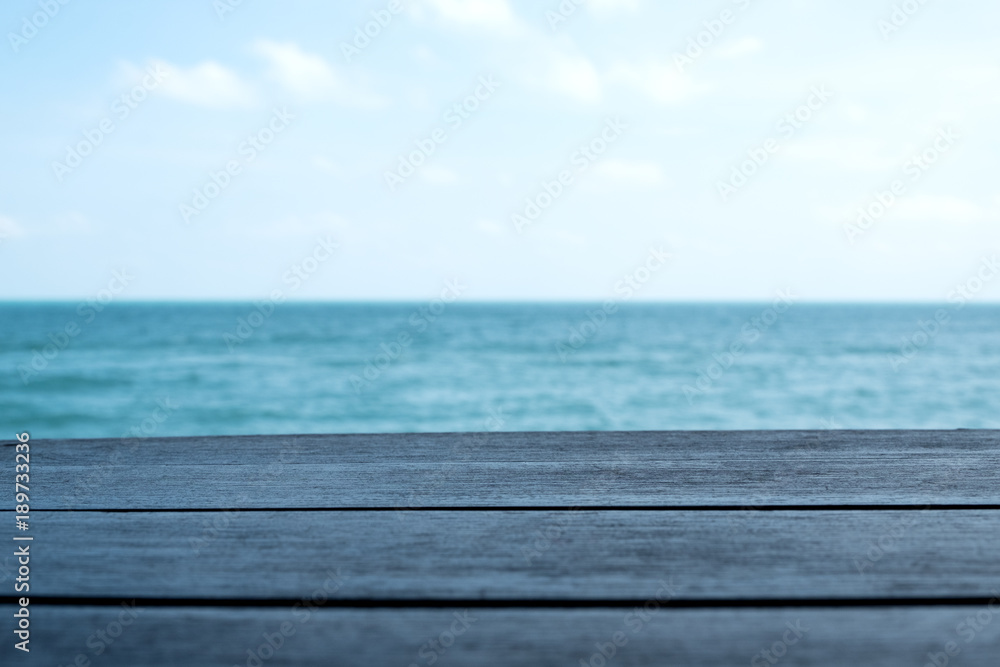 Wooden table with the sea and blue sky background