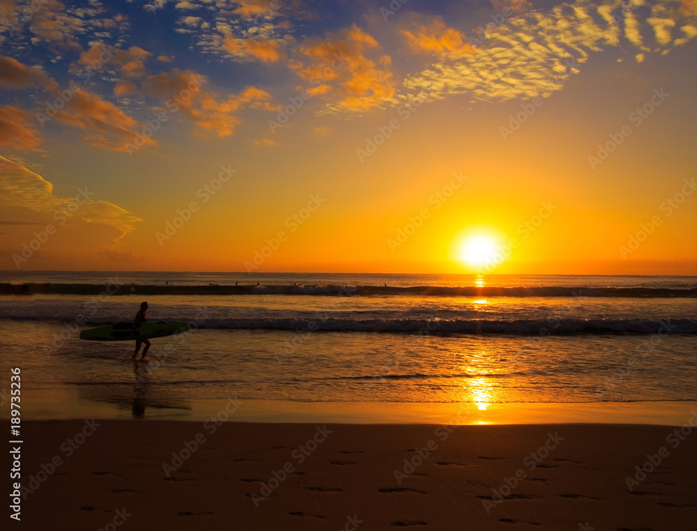 Silhouette Of  Man surfer carrying their surfboard on the beach with sunrise sky scene